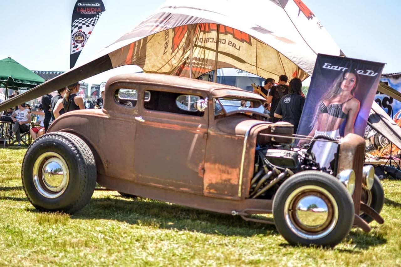 Un hot rod con la chapa oxidada sobre el césped